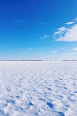A sprawling untouched snowy field under a cloudless bright blue sky  AI generated illustration