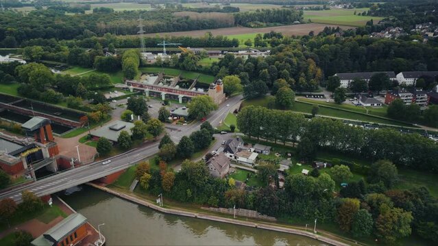 Aerial drone footage of small houses and infrastructure in Europe Germany. Green trees, road and water canal near Waltrop city.