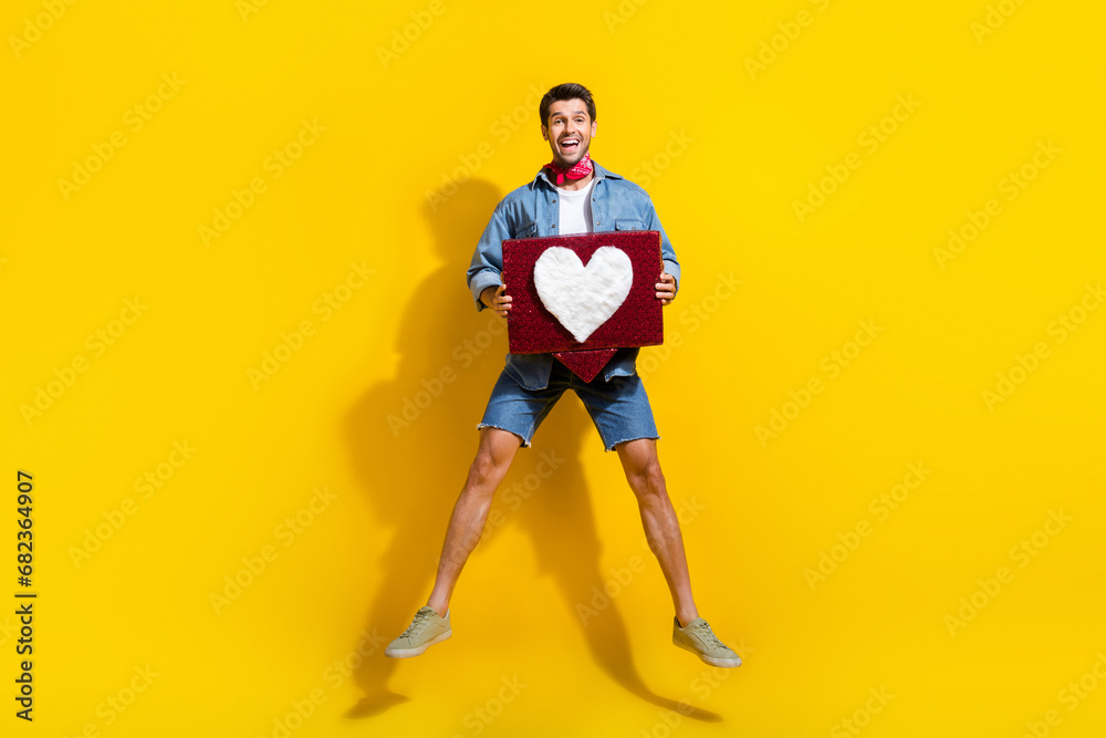 Poster full size photo of overjoyed guy wear jeans jacket shorts jumping hold heart tap like on comment iso