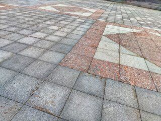 paving stone tiles of square and rectangular shape of gray in perspective. Close up road surface....