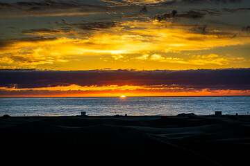 Obraz premium Sunrise over the Atlantic Ocean. Shot from the Dunes of Maspalomas Gran Canaria