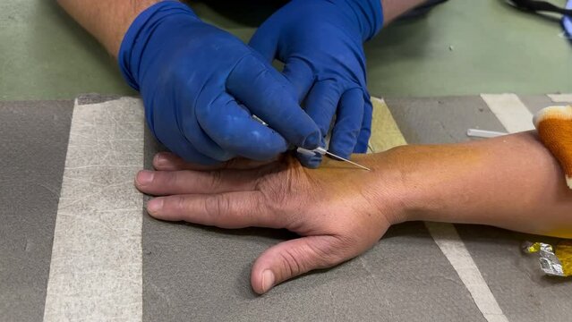 Placement of cannula on hand lubricated with betodyne during training for profession of military paramedic, placement of cannula, war in Ukraine