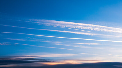Cloudscape with trail of jet plane. Vapor trail from jets in a blue sky - obrazy, fototapety, plakaty