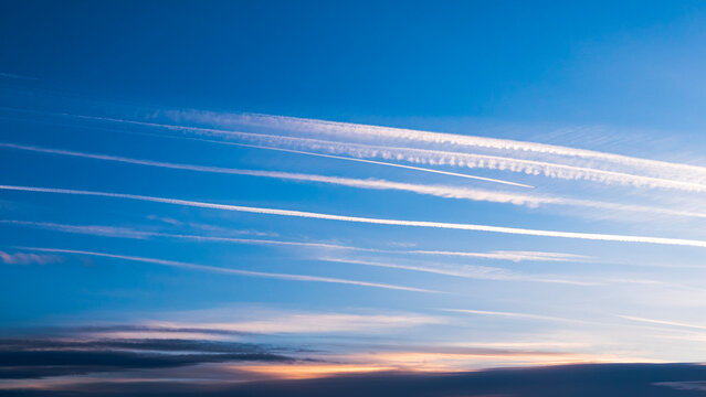Cloudscape with trail of jet plane. Vapor trail from jets in a blue sky