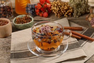 Aromatic tea with different dry herbs and flowers on wooden table