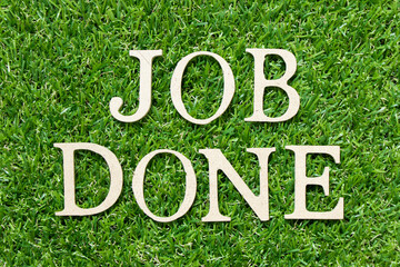 Wood letter in word job done on green grass background