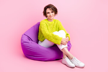Full length photo of cute adorable lady wear knitter pullover sitting bean bag having rest isolated...