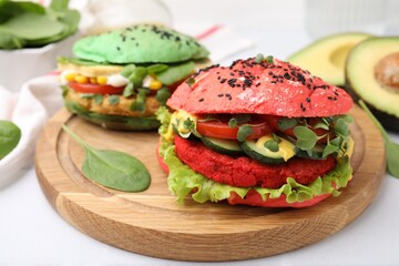 Tasty pink vegan burger with vegetables, patty and microgreens on white table, closeup. Space for text
