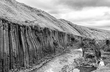 Jokla River cuts through the Studlagil canyon and passes by the hexagonal basalt columns caused by...