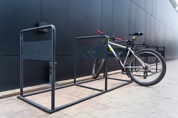 Bicycle Secured to a Modern Bike Rack by a Black Building