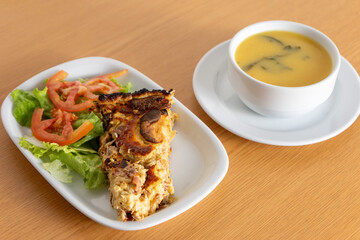 Mouthwatering mushroom quiche paired with fresh salad and a comforting turnip greens soup, served at a cozy snack bar.