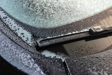 Frozen car windscreen wipers on winter morning. Close up view. - obrazy, fototapety, plakaty