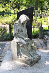 Antique sculpture over the headstone of an old grave at Lukyanivskyi cemetery in Kyiv, Ukraine