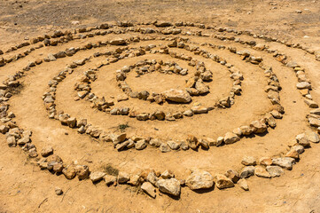 Fototapeta na wymiar Mysterious spiritual stone spiral in circular pattern found on clifftop on Mediterranean island of Ibiza
