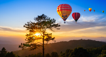 Colorful hot air balloons flying over mountains at sunset in Chiang Mai, Thailand. Hot Air Balloon...