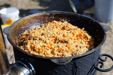 Uzbek national dish pilaf rice in a cast iron cauldron