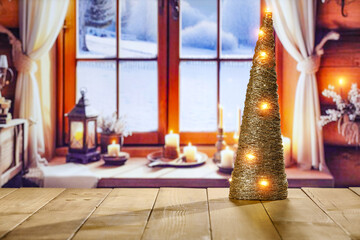Wooden desk of empty space for your decoration. Christmas tree and lights. Blurred window sill background with winter view. Winter landscape and cold december day. Christmas mockup and pedestal. 