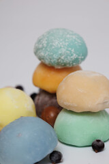 Japanese rice desert mochi closeup. Colouful mochi cakes sliced. Tasty fruit and chocolate mochi on grey background. Traditional cold ice asian candy. Dry fruits and nuts.