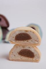 Japanese rice desert mochi closeup. Colouful mochi cakes sliced. Tasty fruit and chocolate mochi on grey background. Traditional cold ice asian candy. Dry fruits and nuts.