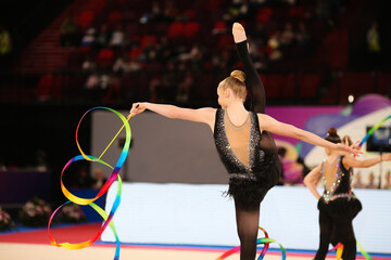 Young gymnasts dance with colored ribbons. Rhythmic gymnastics team competitions