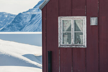 Winter Cabin in Greenland with Red House and Snowy Mountain View