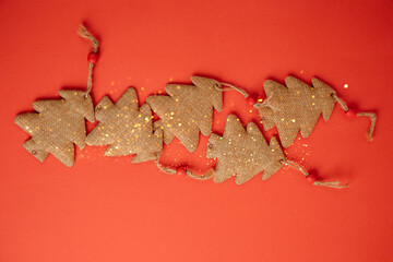 Christmas greeting background with empty space. Brown Christmas trees on a red background with yellow lights. Top view