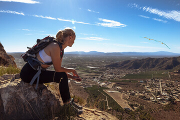a girl in sportswear with a backpack sits on the mountain admiring the views. Hiking concept