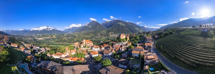 Tourism of northern Italy. Traditional picturesque mountain village Schenna (Scena) near Merano town in Trentino - Alto Adige region. view of medieval castle, aerial  panoramic drone view - obrazy, fototapety, plakaty