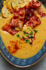 Pumpkin cream soup, curry, fried bacon, bruschetta chips,micro-greens, top view, no people,