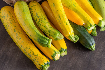 Yellow green leopard spotted zucchini. Vegetables on the table. vegetable marrow harvest. Food background. Fresh courgette, cropped summer squash. Picked courgettes. Still life in kitchen.