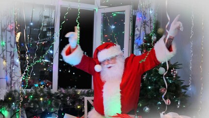 Bearded Santa Claus in red costume dances energetically, shakes his belly and waves arms on Christmas background, near pile gift boxes in cozy home decorated festive tree with tinsel and balls. 