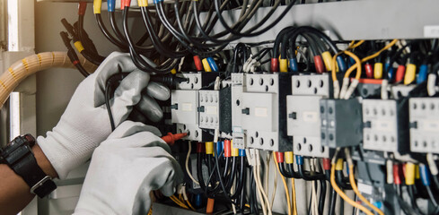 Electrician engineer tests electrical installations and wires on relay protection system.
