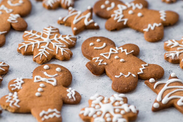 Fototapeta na wymiar Homemade gingerbread Christmas cookies in icing sugar. Delicious gingerbread cookies on the background of a bokeh of Christmas tree lights. Freshly baked Christmas gingerbread cookies.