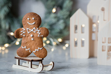 Homemade gingerbread Christmas cookies in icing sugar. Delicious gingerbread cookies on the background of a bokeh of Christmas tree lights. Freshly baked Christmas gingerbread cookies. - obrazy, fototapety, plakaty