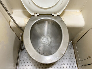 A stainless steel toilet that has just been used for urination and has not been flushed. Foamy...