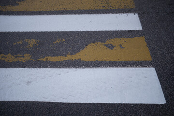 Fototapeta premium Pedestrian crossing. White and yellow stripes. Pedestrians and just people walk along the pedestrian crossing. Zebra Stripe