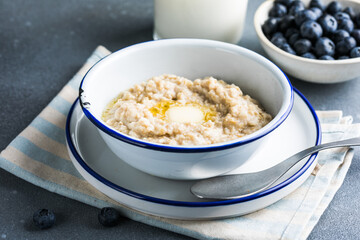 Oatmeal porridge in white bowl, close up view.Oatmeal bowl. Oat porridge with banana, blueberry, walnut, chia seeds and oat milk for healthy breakfast. Healthy diet food. Top view
