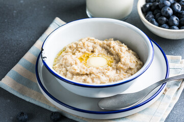 Oatmeal porridge in white bowl, close up view.Oatmeal bowl. Oat porridge with banana, blueberry, walnut, chia seeds and oat milk for healthy breakfast. Healthy diet food. Top view