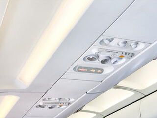 The cabin ceiling of the plane with AC control dial, reading lamp light and flight attendant...