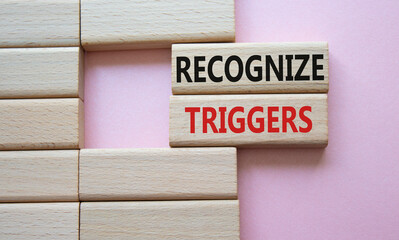 Recognize triggers symbol. Concept words Recognize triggers on wooden blocks. Beautiful pink background. Business and Recognize triggers concept. Copy space.