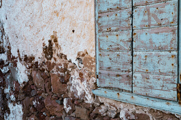 rustic old painted window or door in stone building house, abandoned property