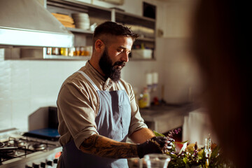 Professional cook in uniform making meal at restaurant kitchen