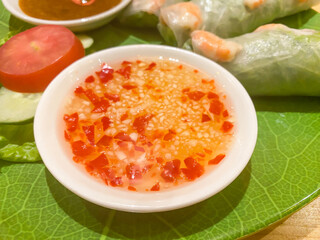 Garlic chili sauce on a small white plate. This food is usually served with other menus such as dim sum or spring rolls and gives a spicy taste.