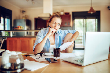 Young woman struggling with paying bills at home