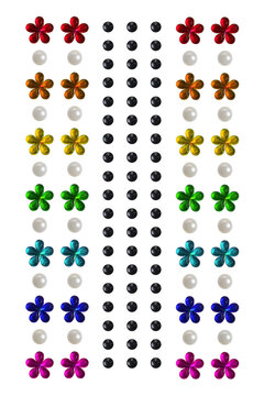 Multicolored floral applique stickers, pearls and rhinestones on white background.