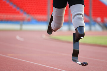disabled man with a leg prosthesis in sports clothing is running in the stadium