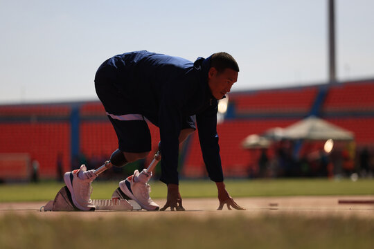 disabled male athlete with a running blade ready to start a run
