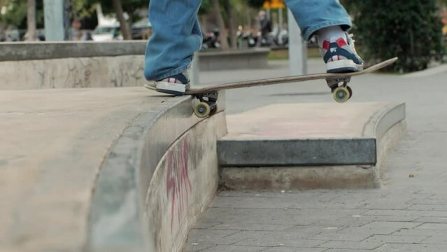 Young skater making jump and tail slide on box, performing trick, skateboarder training in skatepark, making slides and flips, jump over the gap, professional extreme sport athlete training ride 