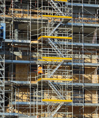 scaffolding on building under construction, external service staircase

