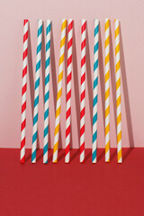 Drinking straws for party on pink and red background. Party and celebration concept.